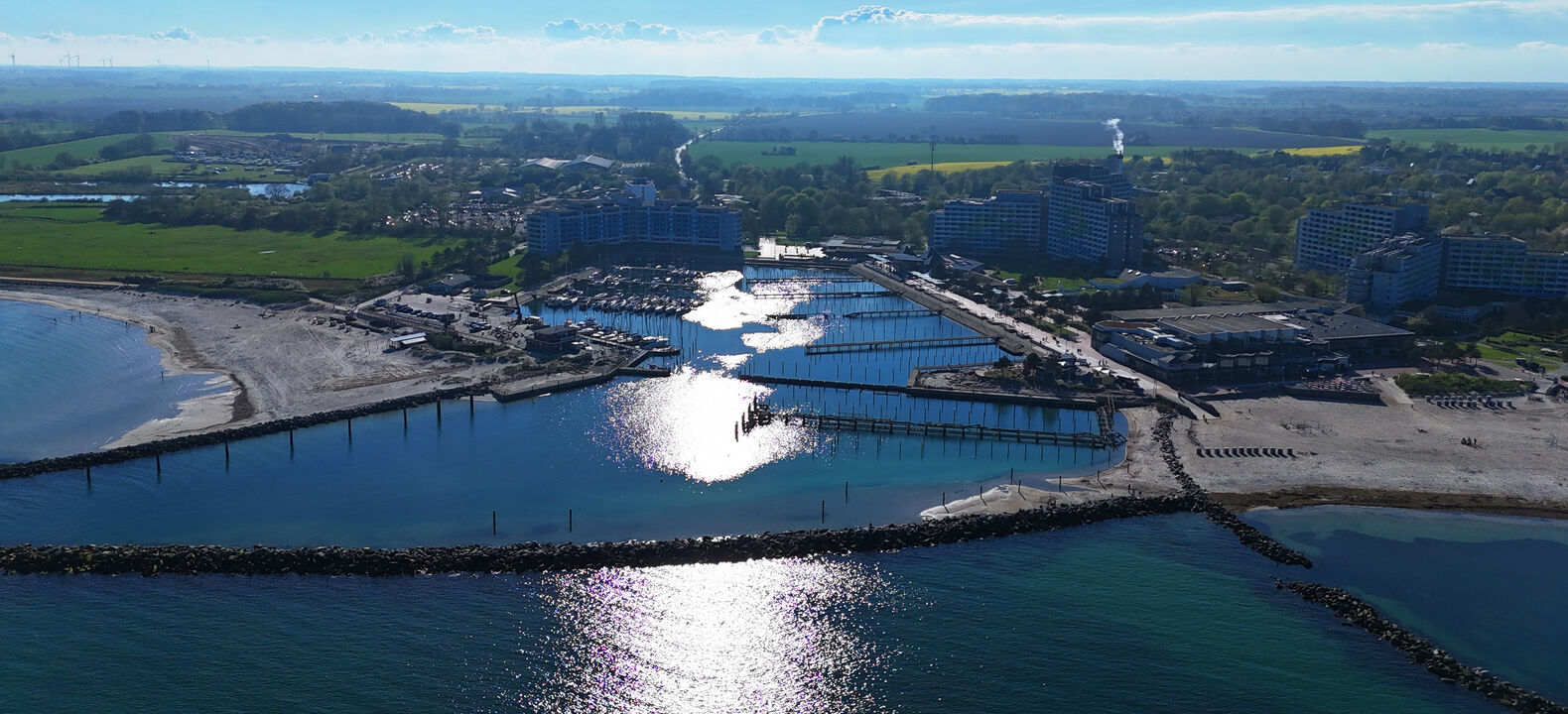 Drohnenbild des Hafens mit blauem Himmel und dem Hinterland